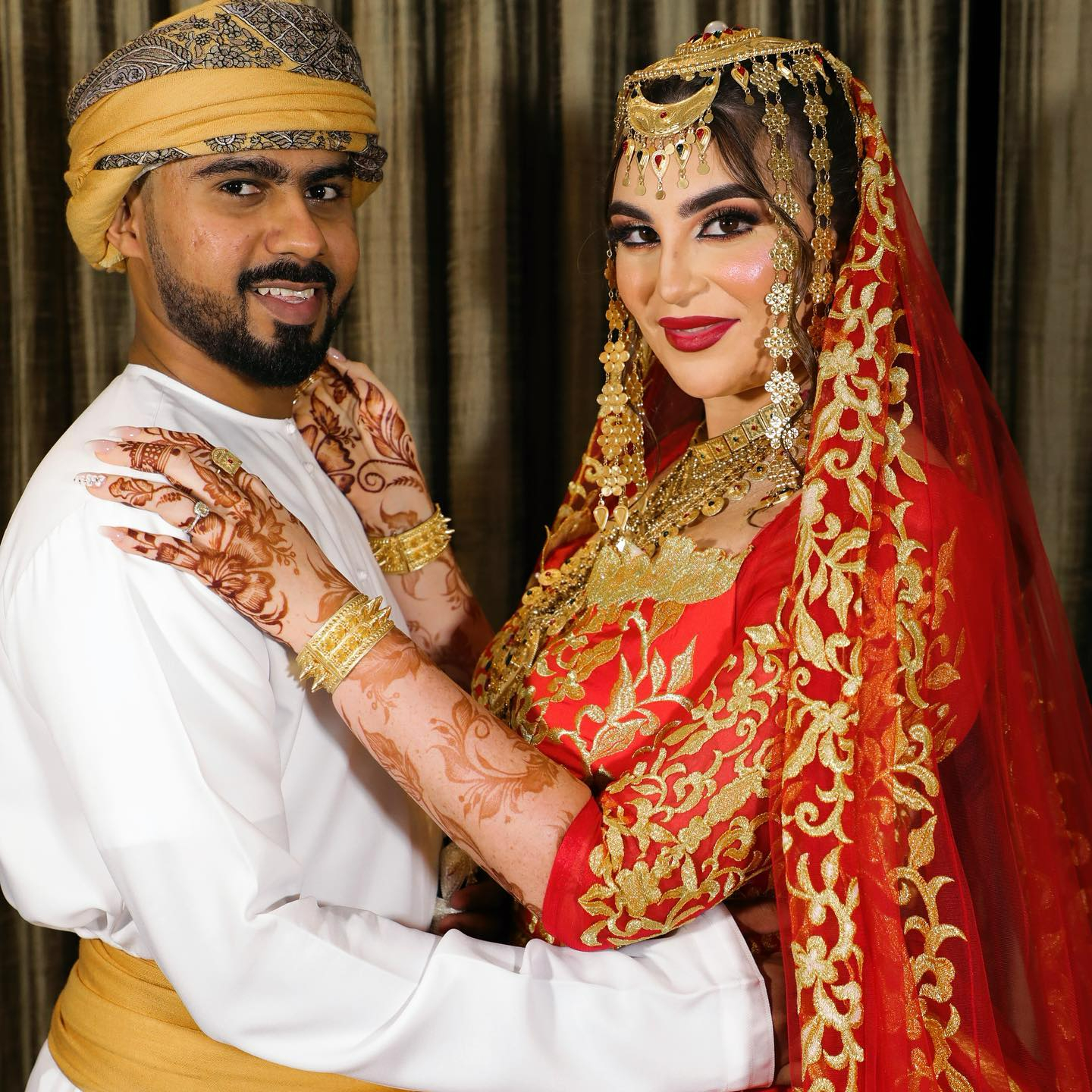 A bride and groom in traditional Omani attire.