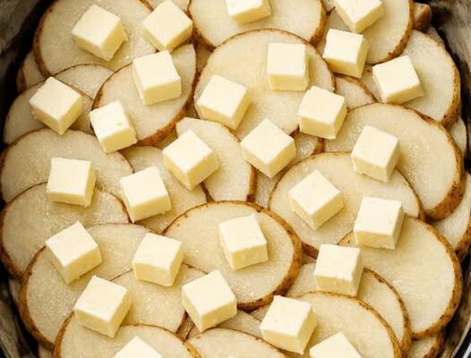 Toss raw sliced russet potatoes into the slow cooker with just 3 other ingredients and somehow you get a